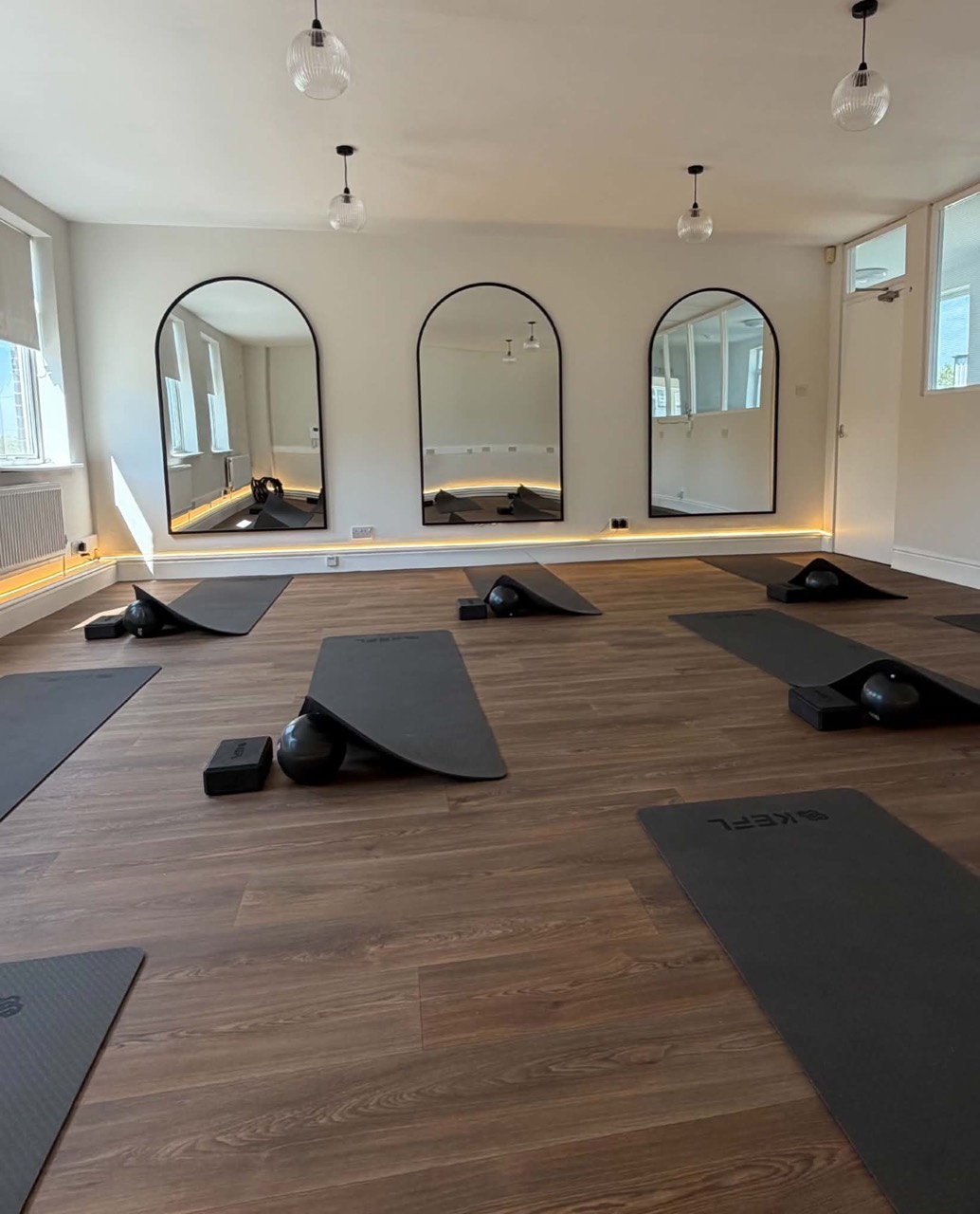 Studio mats arranged facing the arched mirrors